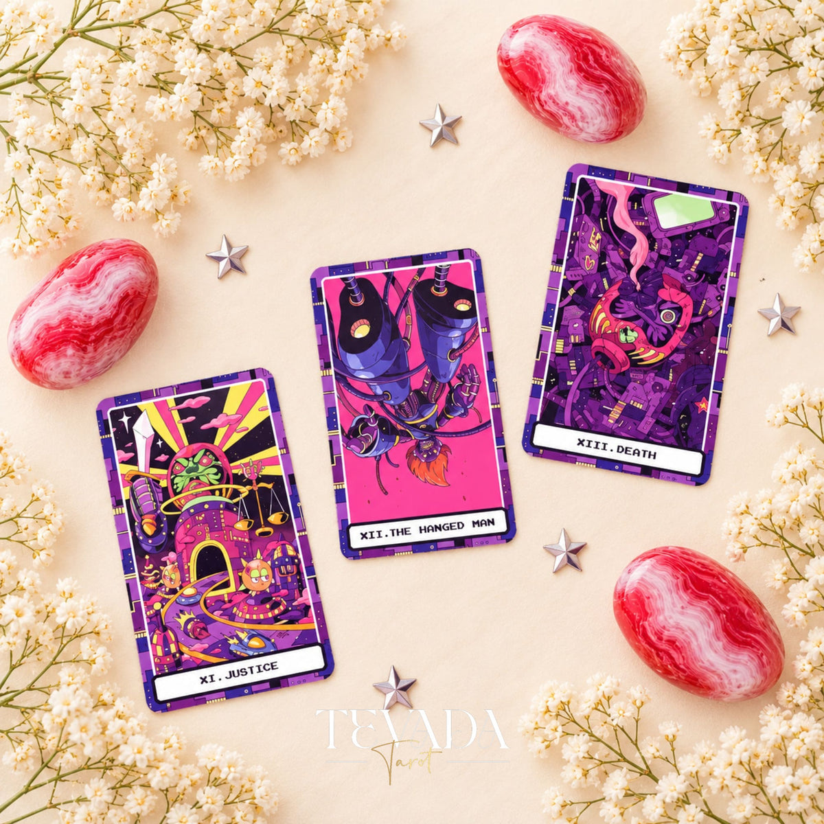 At the Edge of the Galaxy Tarot Justice, The Hanged Man and Death card fronts on a pale background with white flowers.