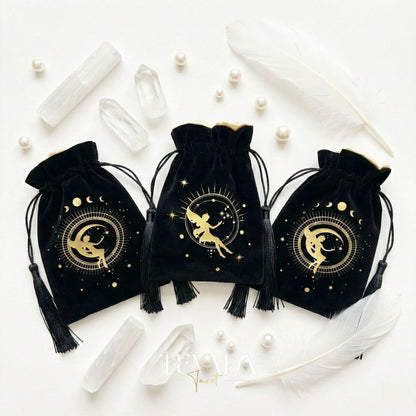 Black velvet tarot pouch with gold stamping and tassels for protecting tarot decks and crystals on a witchy altar.