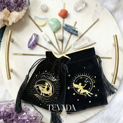 Black velvet tarot pouch with gold stamping and tassels for protecting tarot decks and crystals on a witchy altar.