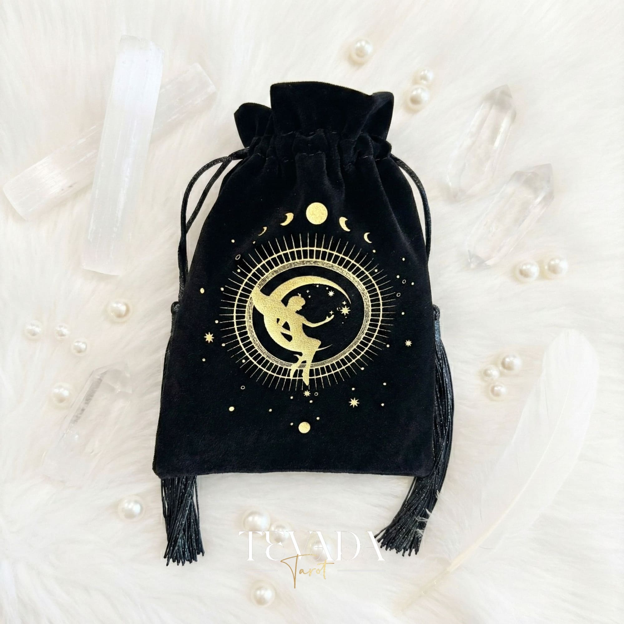 Black velvet tarot pouch with gold stamping and tassels for protecting tarot decks and crystals on a witchy altar.