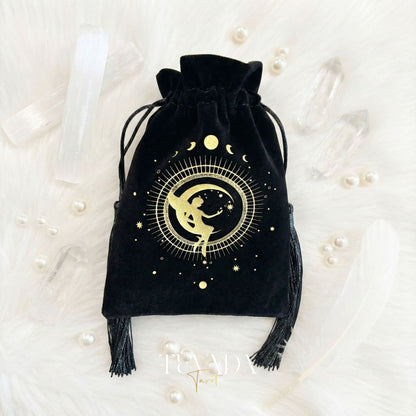 Black velvet tarot pouch with gold stamping and tassels for protecting tarot decks and crystals on a witchy altar.