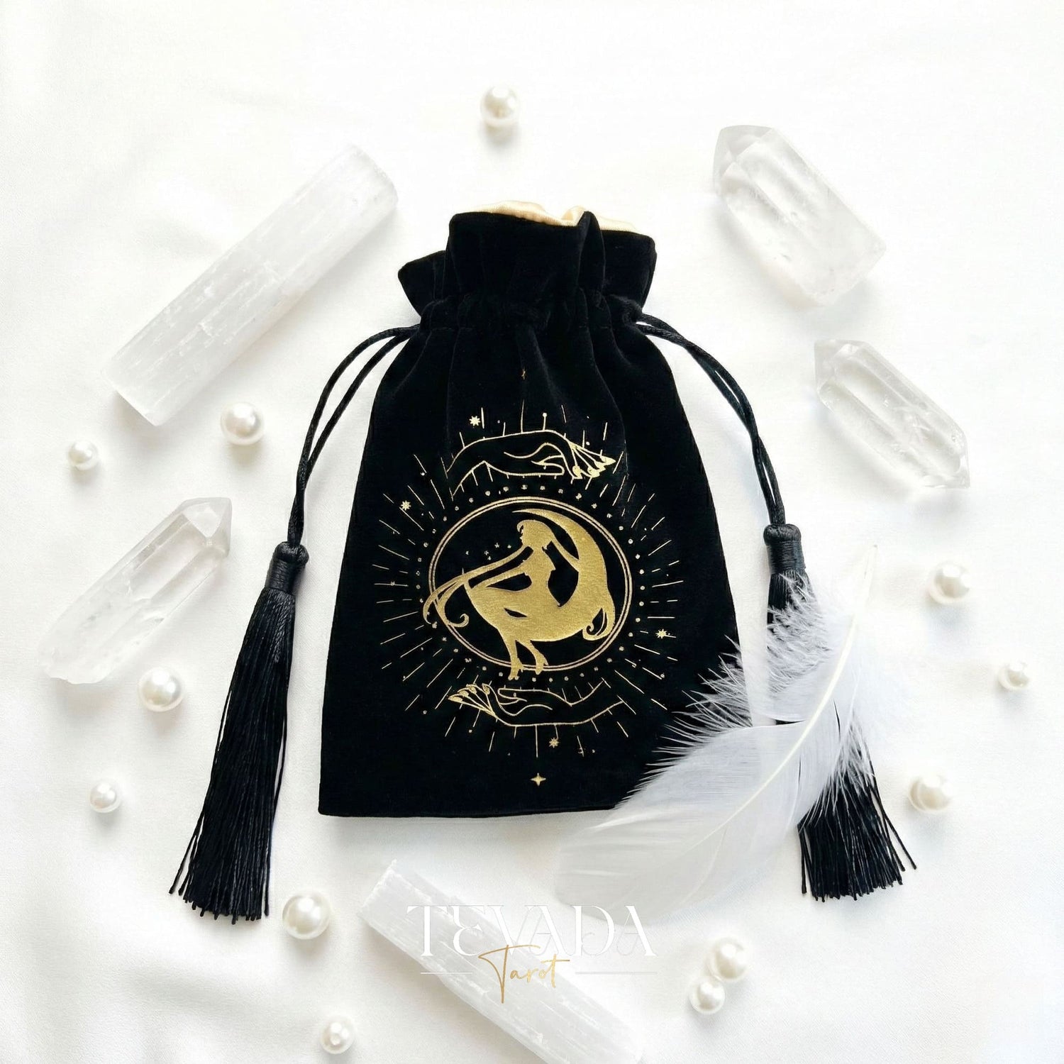 Black velvet tarot pouch with gold stamping and tassels for protecting tarot decks and crystals on a witchy altar.