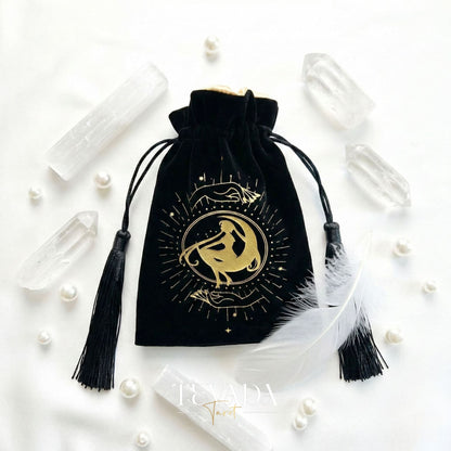 Black velvet tarot pouch with gold stamping and tassels for protecting tarot decks and crystals on a witchy altar.