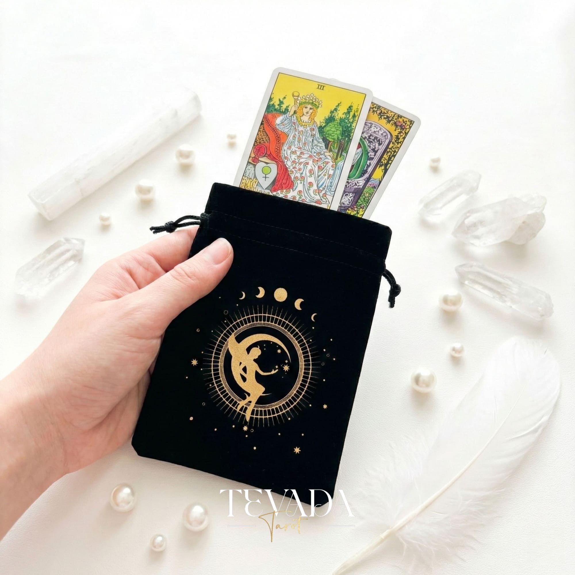 Bolsa de tarot de terciopelo negro con estampado dorado y borlas para proteger barajas de tarot y cristales en un altar de brujas.