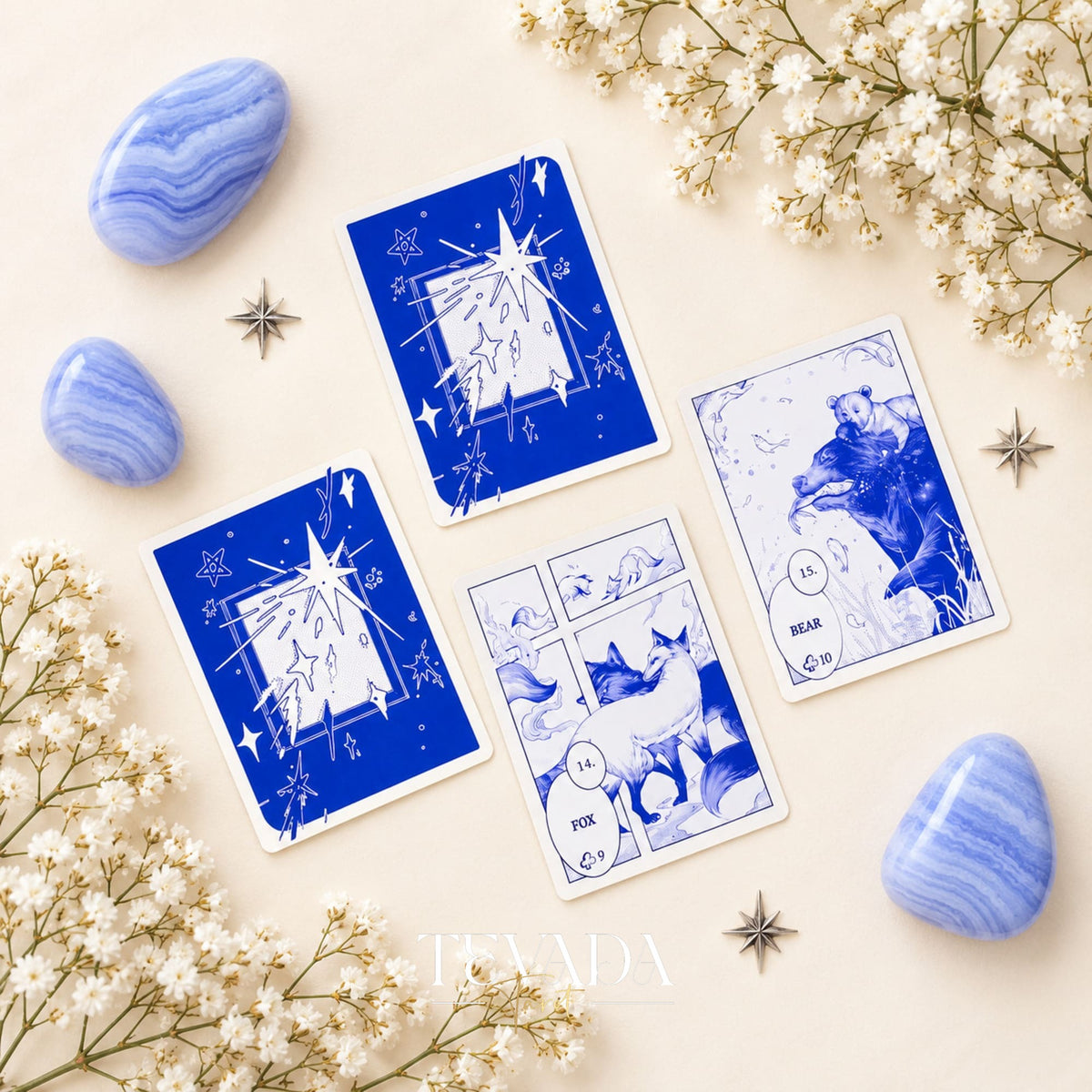 Two blue Lenormand cards with comic-style illustrations, including a stork in flight and a dog, arranged among stones and star motifs.