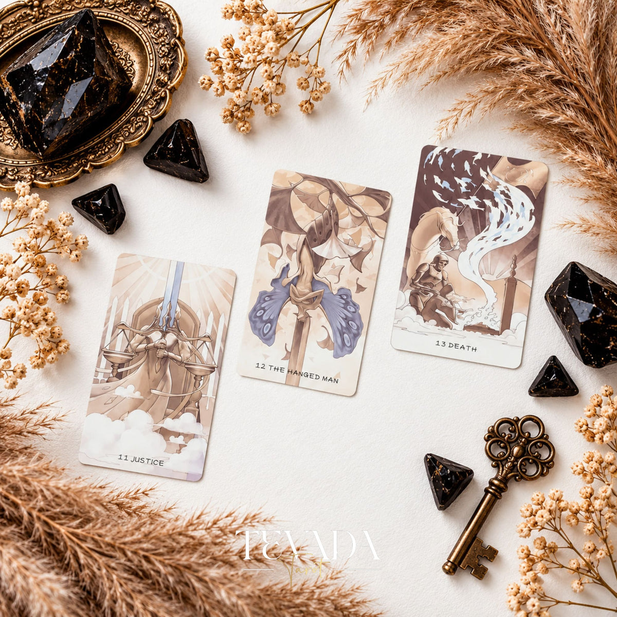 Three surreal sepia tarot card fronts from Ethereal Poetry Tarot Deluxe arranged with black crystals and dried grasses.