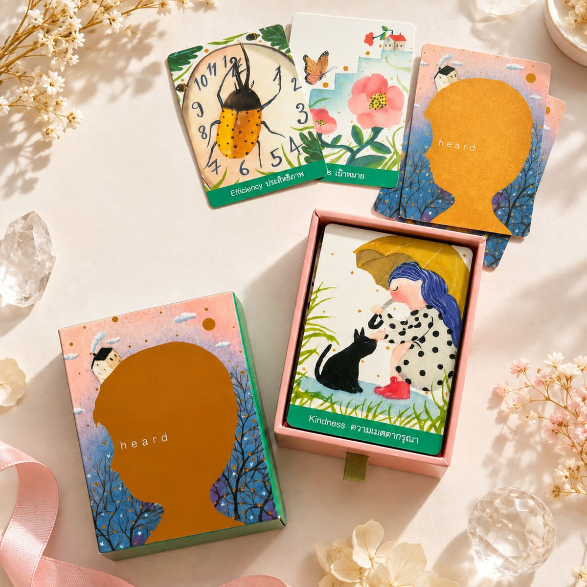 Heard Oracle deck and sliding box with bilingual storybook cards, including a girl with a black cat.
