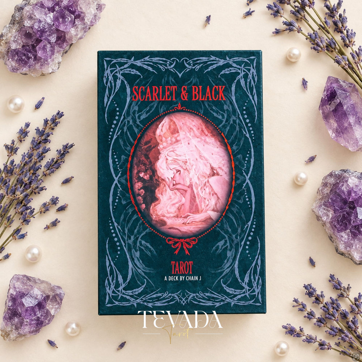 Scarlet &amp; Black Tarot box and gothic illustrated cards arranged on a cream surface with purple amethyst crystals, pearls and lavender sprigs.