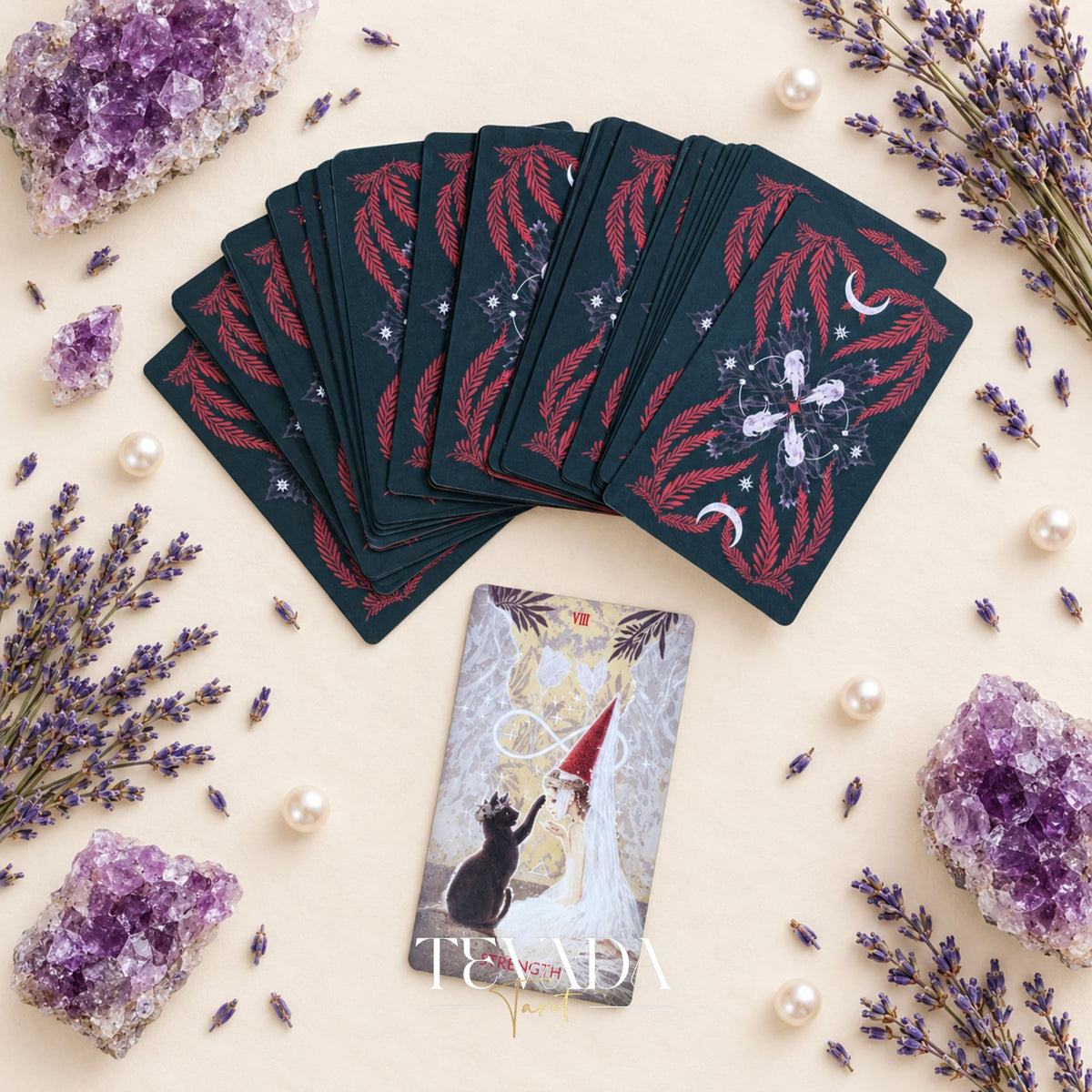 Scarlet &amp; Black Tarot cards with dramatic figures and symbols, including a circular Wheel of Fortune scene, on a cream botanical surface.