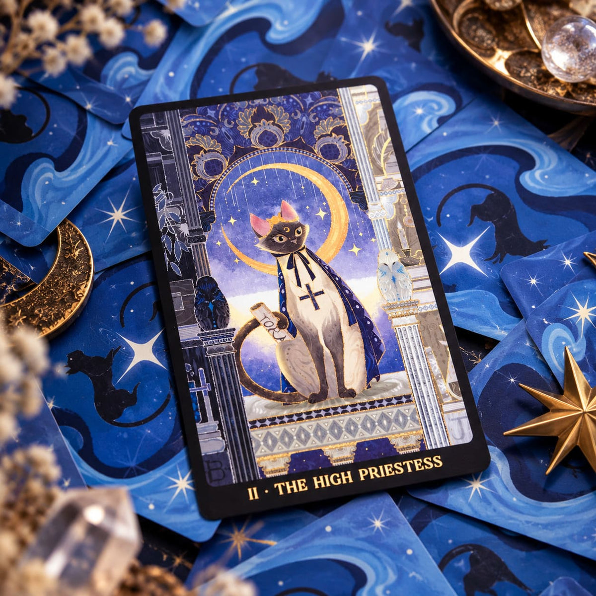 Tales of Catrealm Tarot DELUXE Edition The High Priestess cat card displayed on blue celestial fabric.