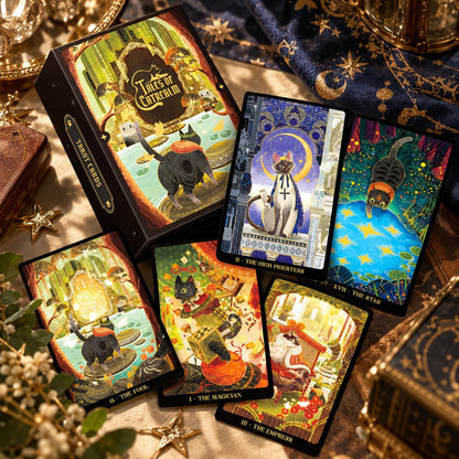 Tales of Catrealm Tarot DELUXE Edition box, card backs and face-up illustrated cat cards on dark fabric.
