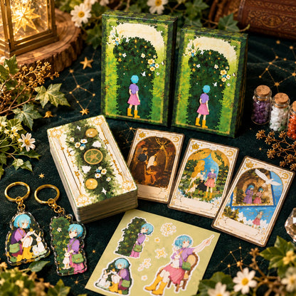 The Hedge Maze Tarot boxes, card backs, face-up cards and guidebook arranged on green velvet with flowers.