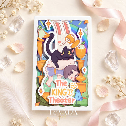 Caja The King Theatre Tarot Edición 2026 y caprichosas cartas ilustradas con personajes escénicos, dispuestas sobre una superficie rosa pálido con cristales.