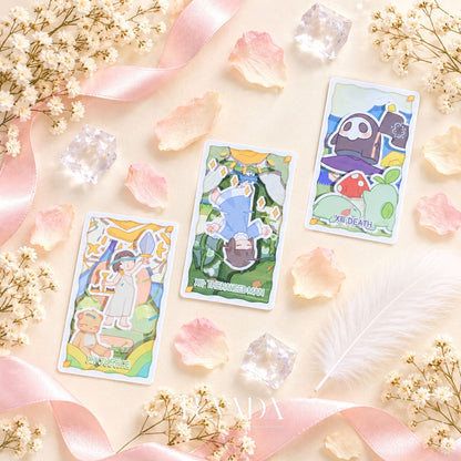 La baraja de Tarot King Theatre y las cartas ilustradas dispuestas con sus bordes verdes mate visibles.
