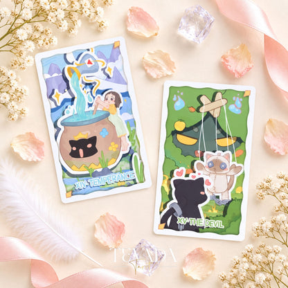Un grupo de cartas del Tarot del King Theatre con personajes divertidos y escenarios, dispuestos sobre un fondo botánico de color rosa pálido.